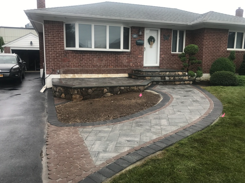 Brick house with curved stone walkway, steps, and small front yard.