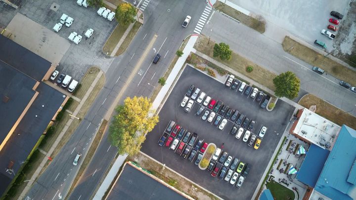 A row of cars are parked in a parking lot.