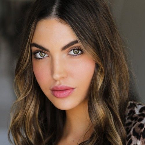 A close up of a woman 's face with a leopard print shirt on