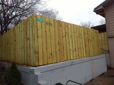 Tall wooden privacy fence with natural finish.