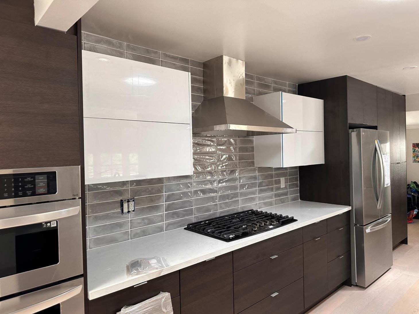 A clean and modern white kitchen with stainless steel appliances and a minimalist design.