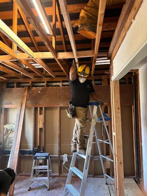 Ongoing home renovation in a room with tools and ladder.