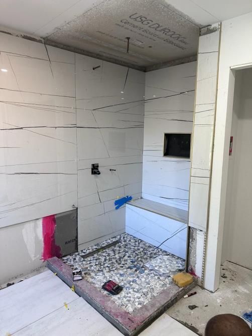 Professional installing ceramic floor tiles during a home renovation project.