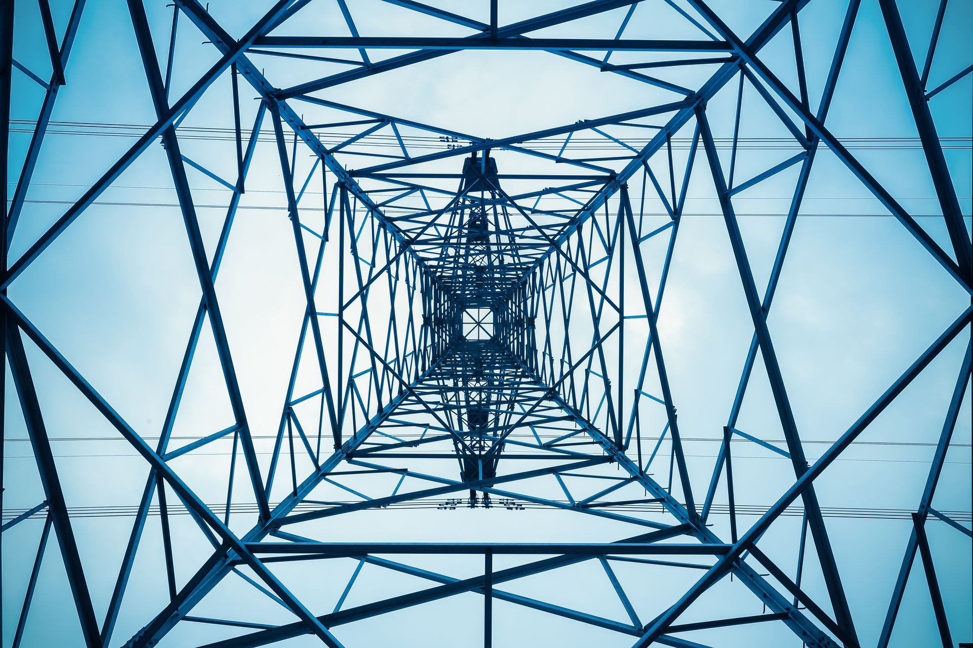 Regardant une tour électrique avec un ciel bleu en arrière-plan.