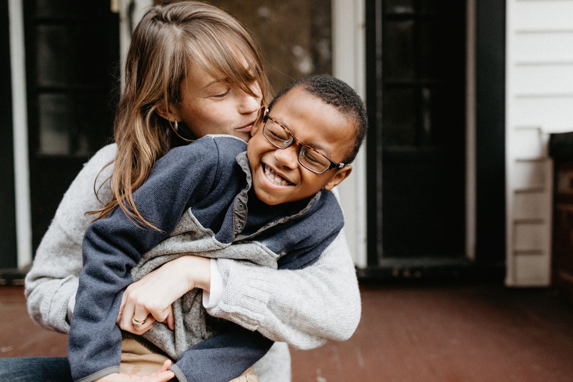 A girl is kissing a boy on the cheek.