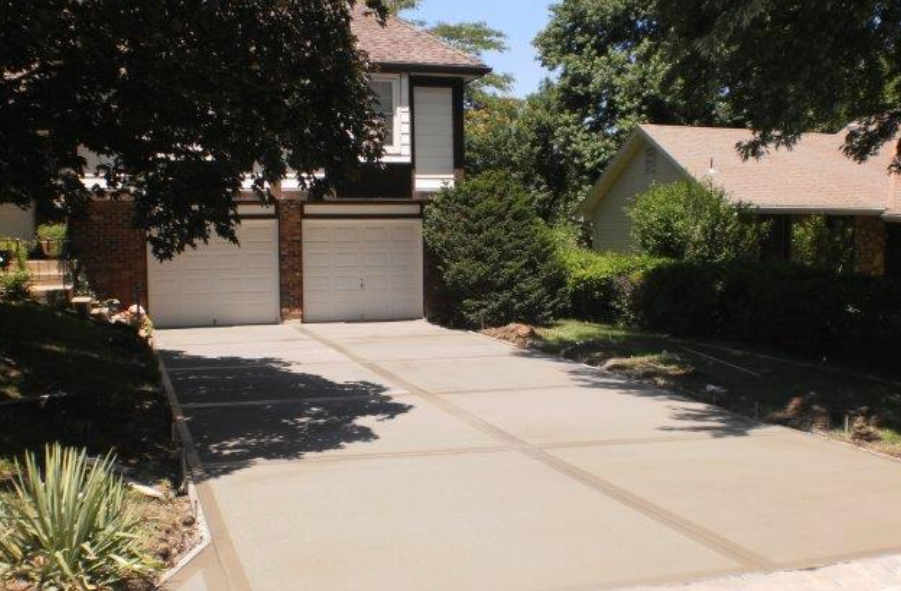 a driveway leading to a house with two garage doors