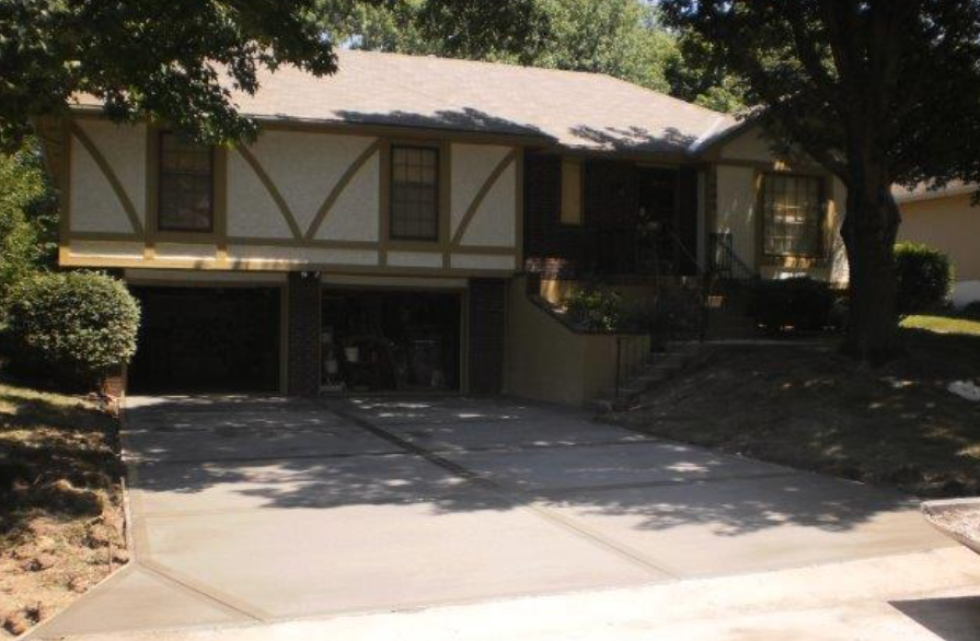 a house with a concrete driveway leading to it