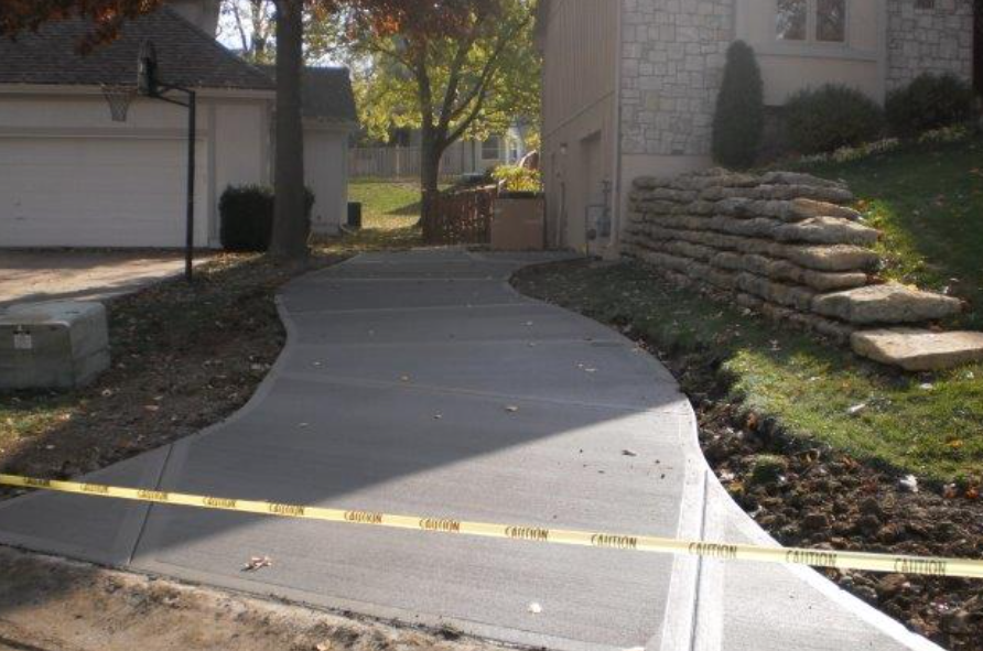 a concrete driveway is being built in front of a house