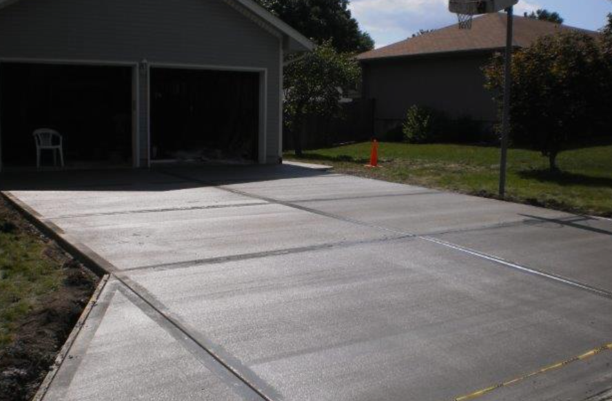a concrete driveway is being built in front of a garage .