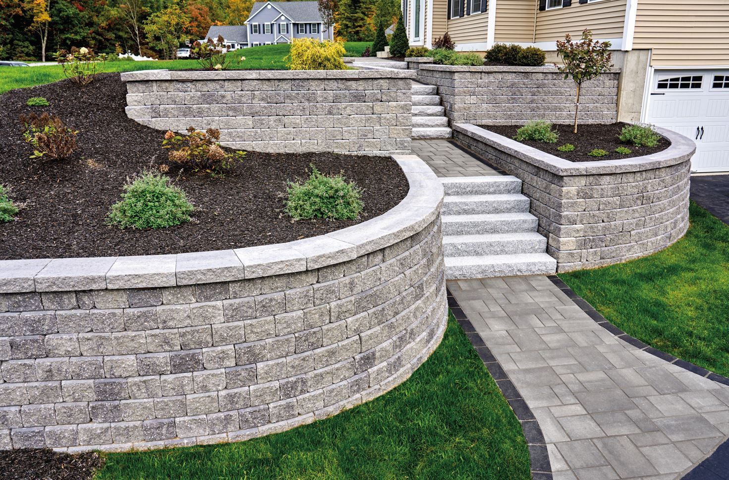 a brick wall with stairs and a walkway in front of a house .