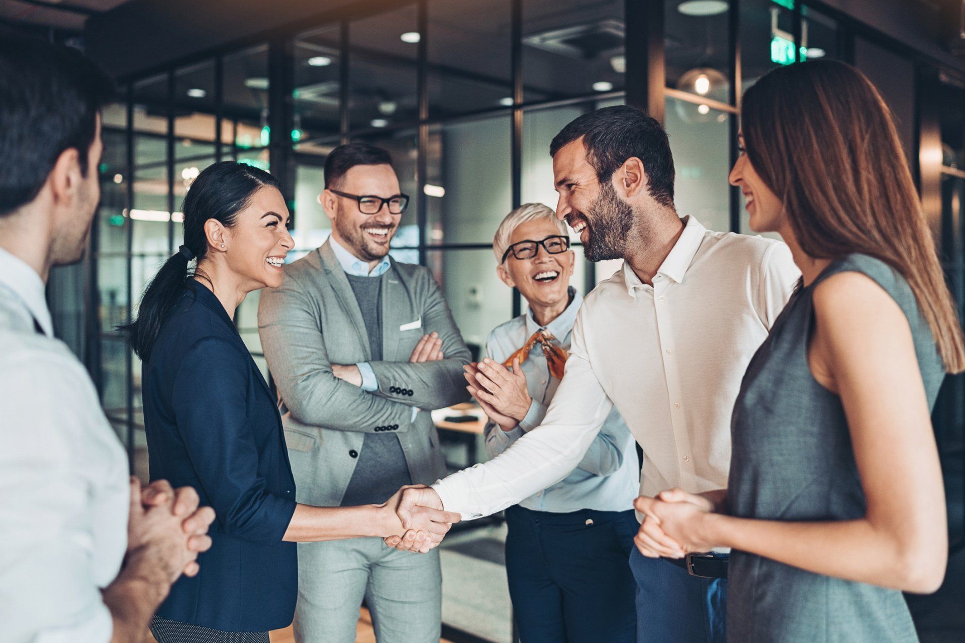 a group of business people are shaking hands in an office