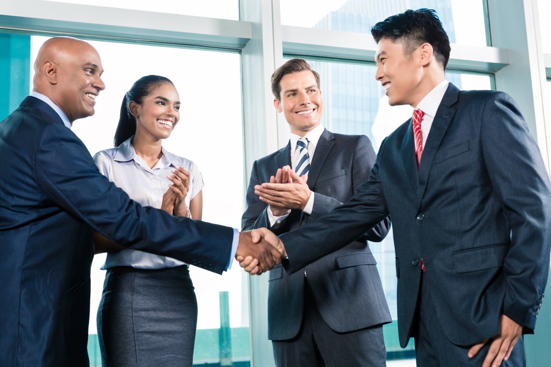 a group of business people are shaking hands in front of a window