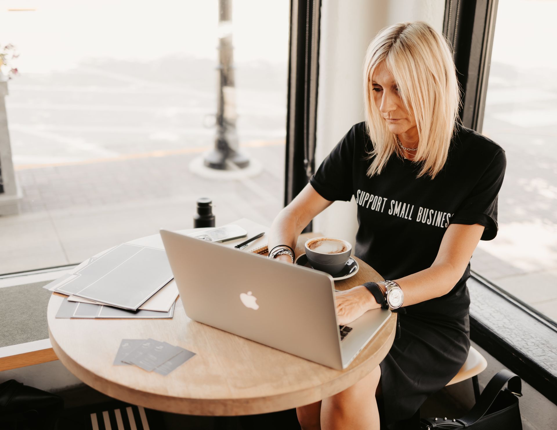 A woman is sitting at a table using a laptop computer.