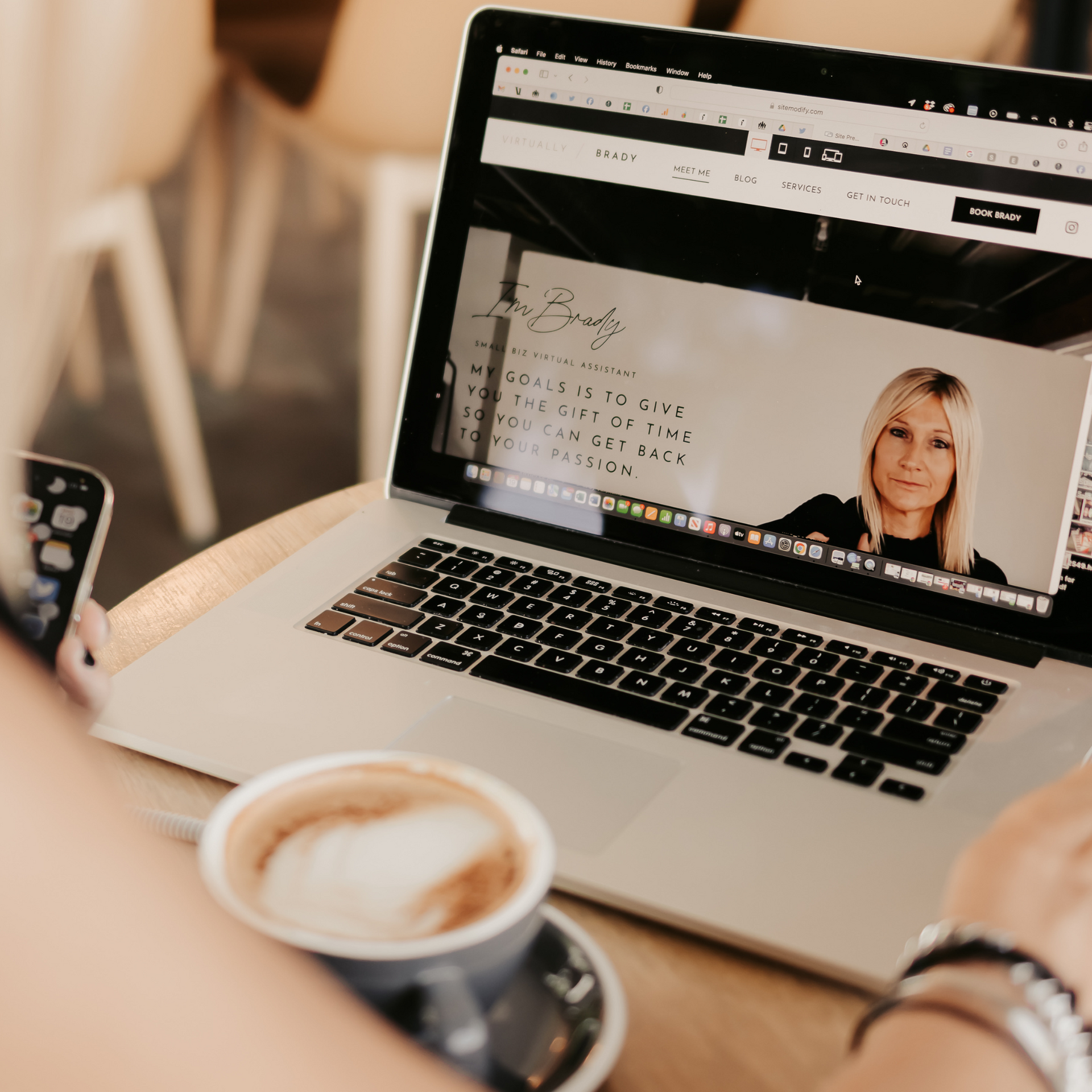 A person is sitting at a table with a laptop and a cup of coffee