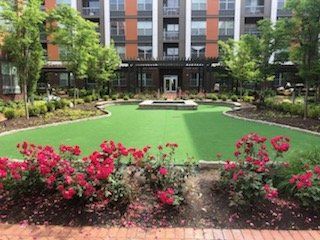 A large building with a green lawn and flowers in front of it.