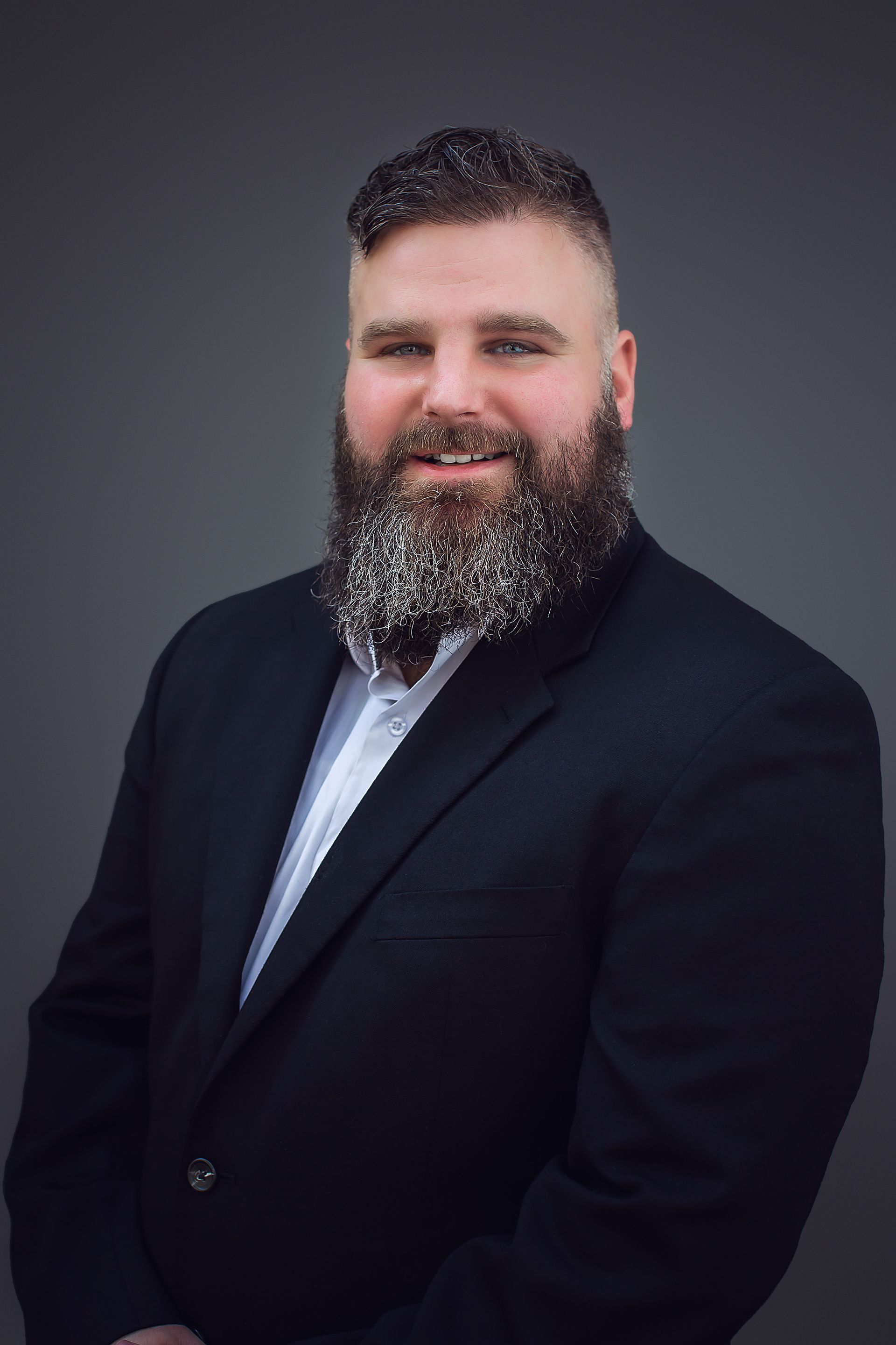 A man with a beard is wearing a suit and bow tie.