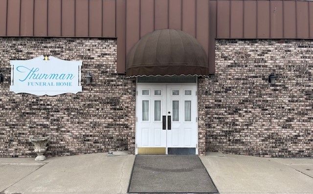 Storefront with white double doors, brown awning, and sign reading “Tortman Physical Therapy.”