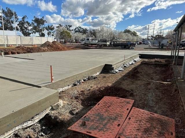 A Row Of Metal Rails Are Lined Up In A Barn — Lonnie Henderson Concreting In Dubbo, NSW