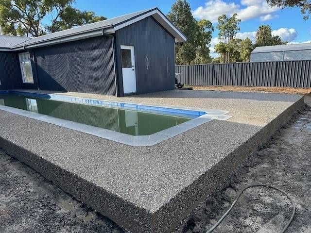 A Person Is Using A Trowel To Plaster A Wall — Lonnie Henderson Concreting In Dubbo, NSW