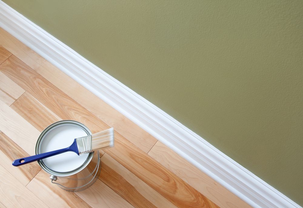 Paint Can With Paintbrush on Hardwood Floor — Israel Jones Painting in Idalia, QLD