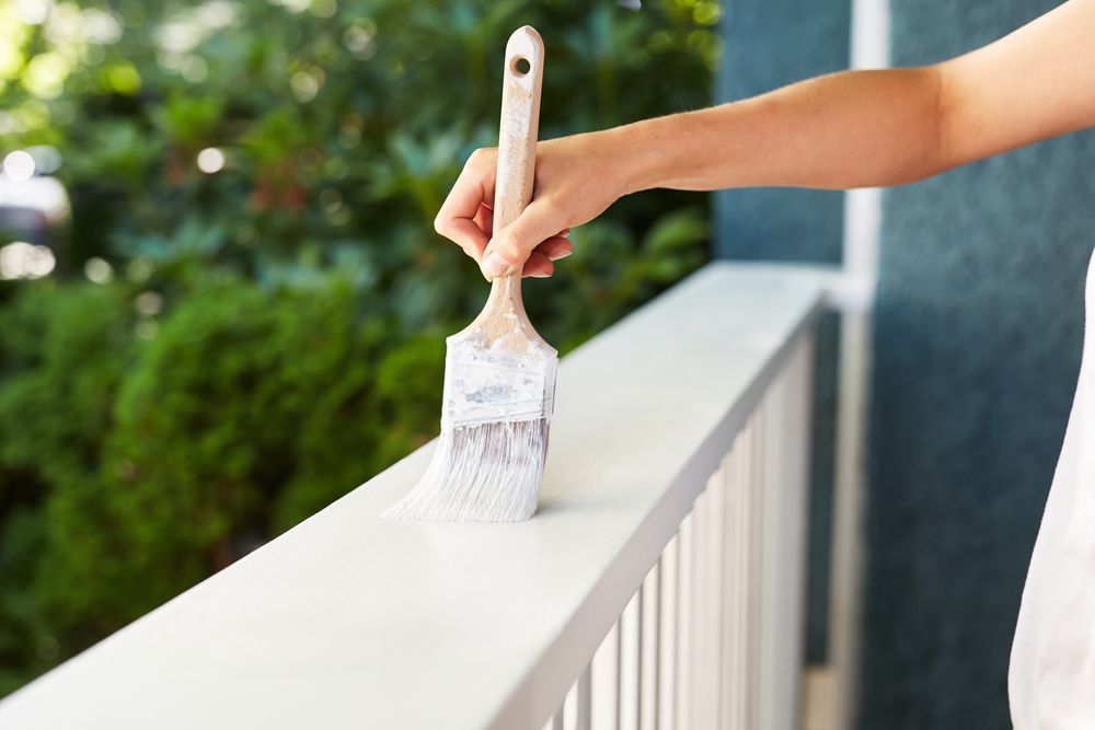 Person Painting a White Railing — Israel Jones Painting in Vincent, QLD