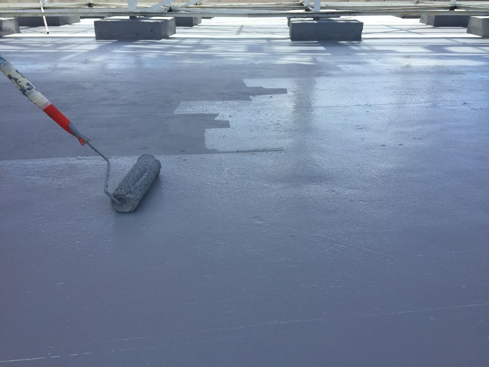 A Person Using a Paint Roller to Apply Gray Coating — Israel Jones Painting in Castle Hill, QLD