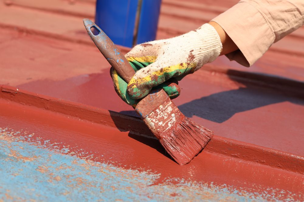 Person Painting a Red Roof — Israel Jones Painting in Vincent, QLD