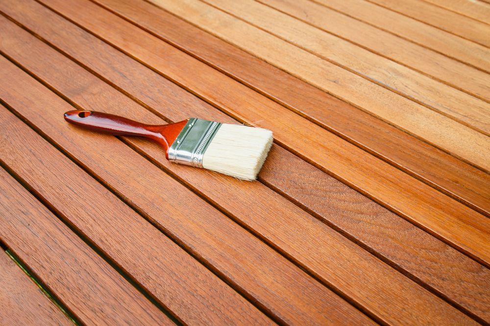 A Paintbrush Applying Stain to a Wooden Surface — Israel Jones Painting in Castle Hill, QLD