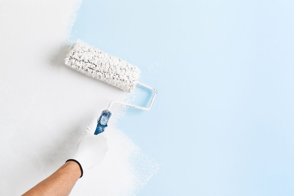 Hand in a White Glove Using a Paint Roller — Israel Jones Painting in Vincent, QLD