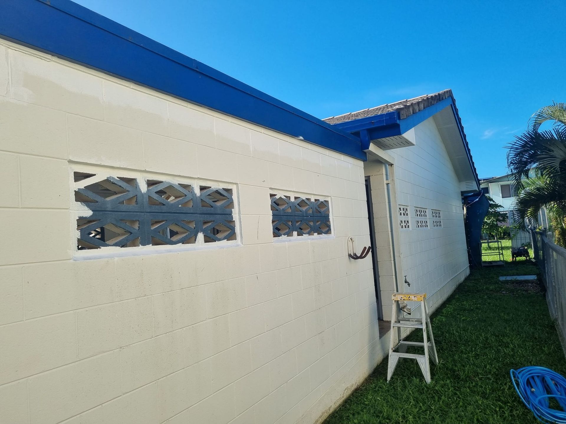 Exterior view of a cream-colored building with blue trim — Israel Jones Painting in Vincent, QLD