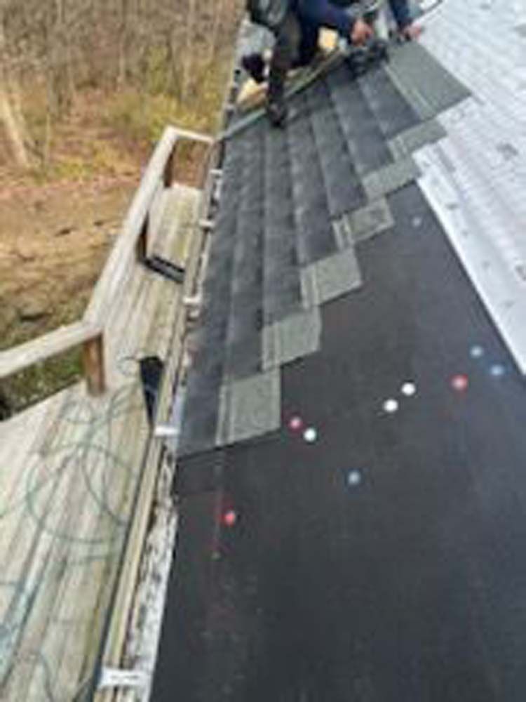 A man is working on the roof of a house.
