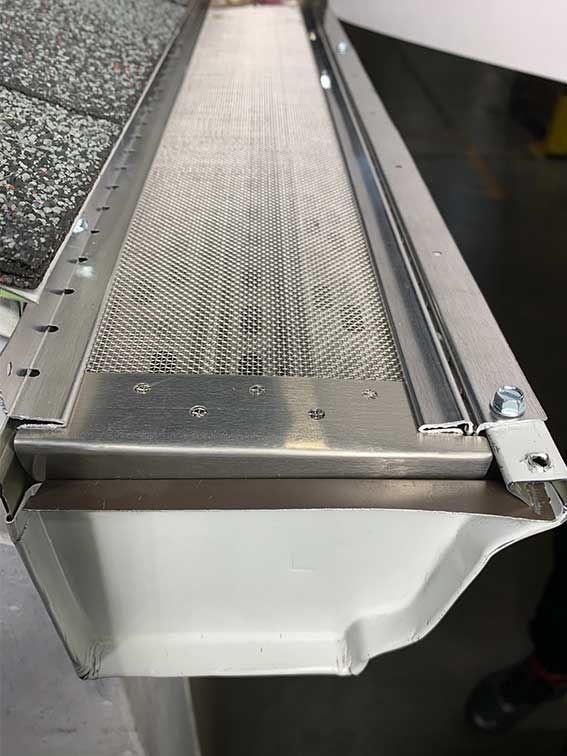 Metal conveyor or walkway with textured surface and white side panel in an industrial setting