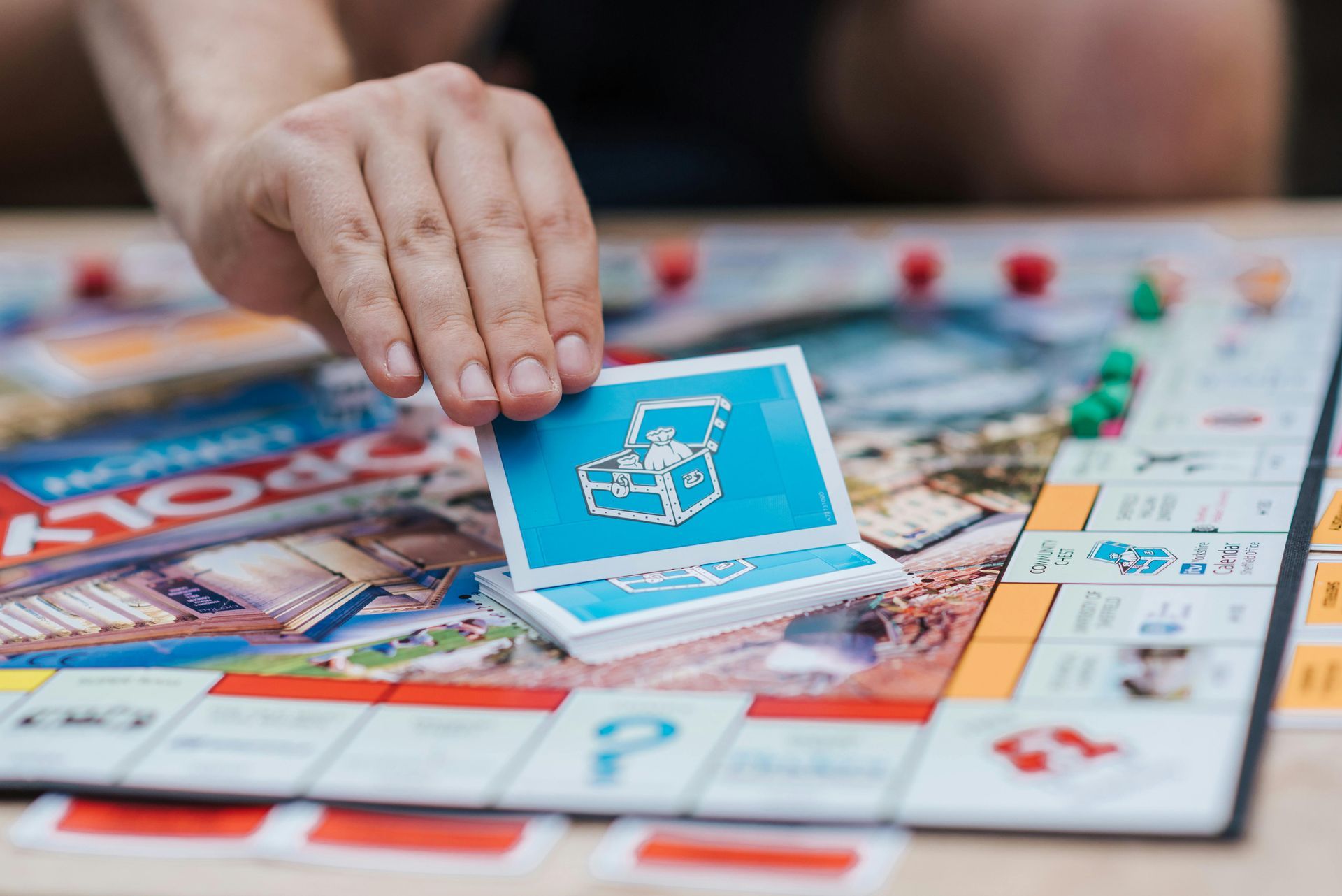 Someone picking up a card while playing monopoly.