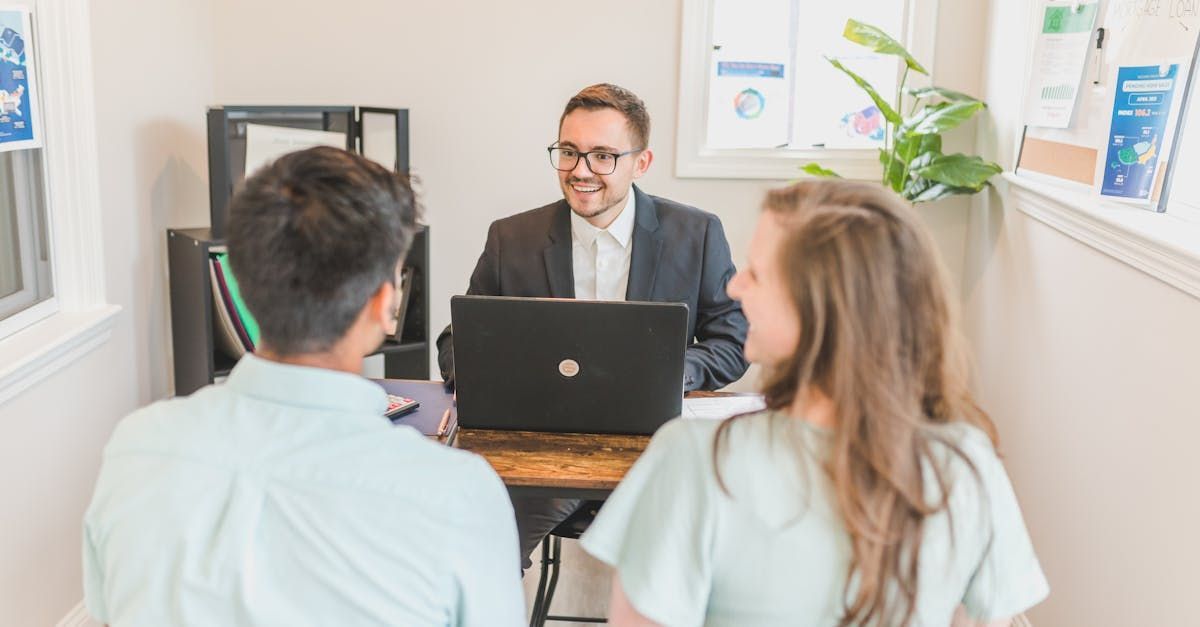 a couple sitting in front of a mortgage loan officer