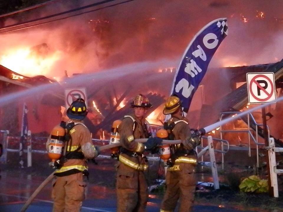 A group of firefighters are spraying water on a fire