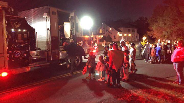 A group of people are standing in front of a fire truck.