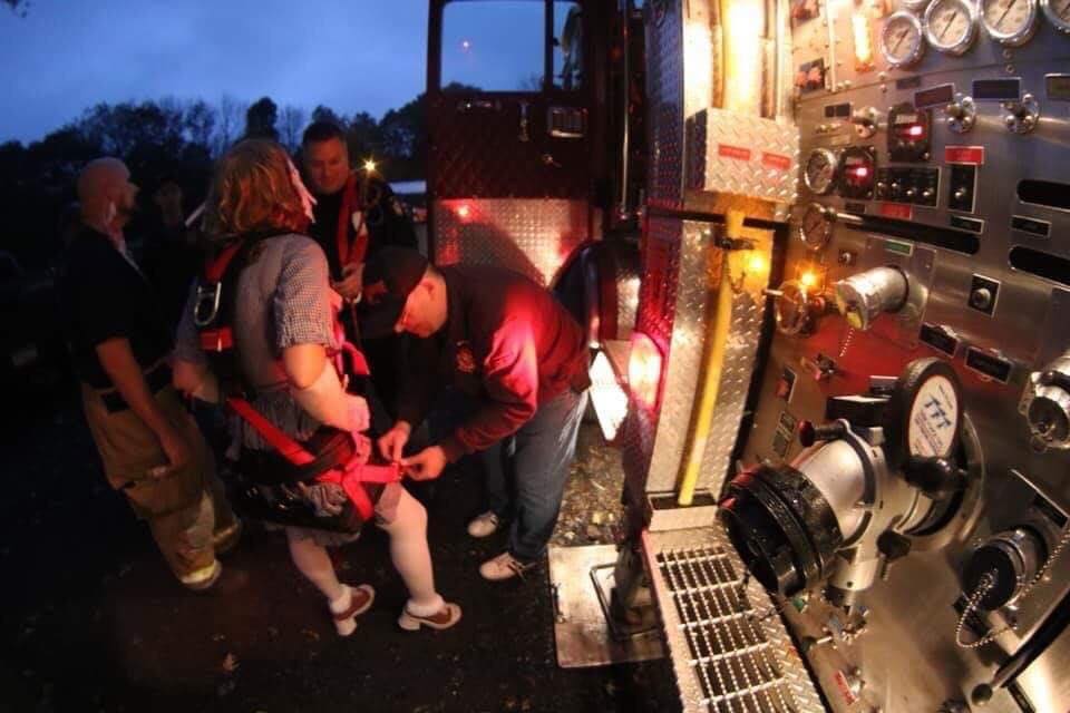 A group of people are standing in front of a fire truck