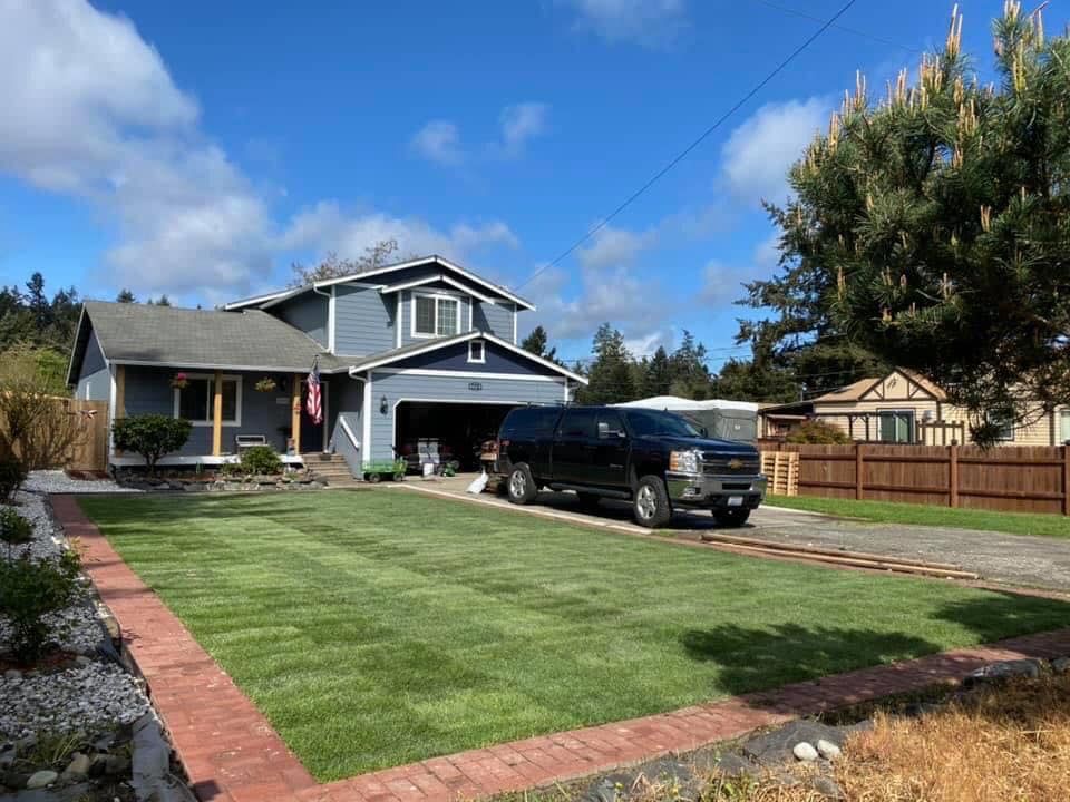 A black truck is parked in front of a house.