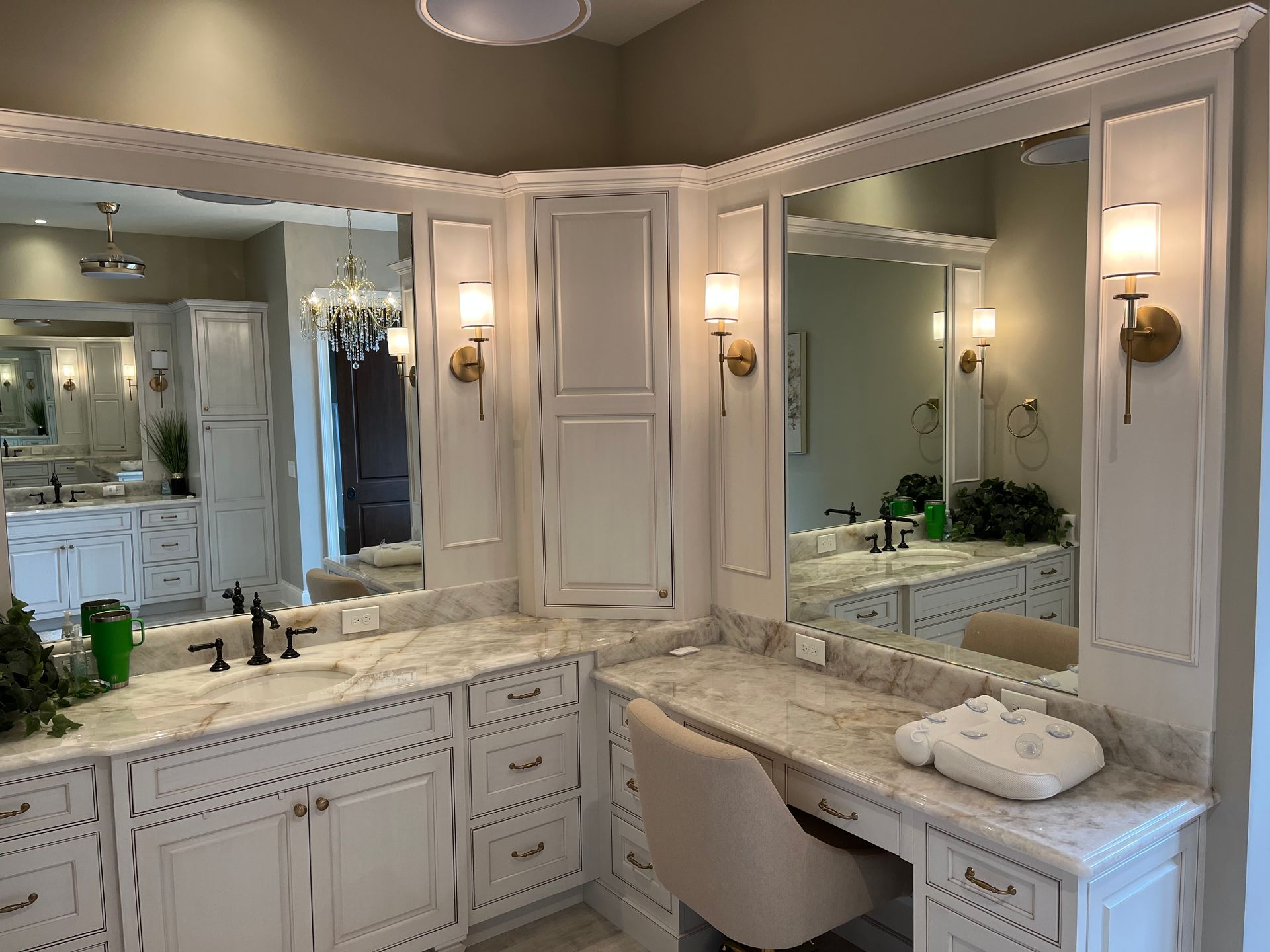 A bathroom with two sinks , a vanity , and a large mirror installed by Reston Construction.