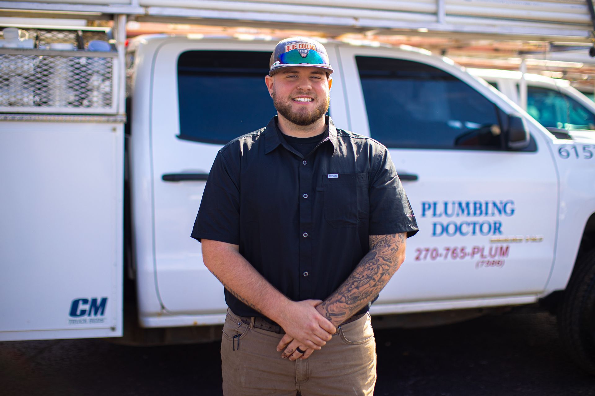 Plumber stands by a white truck with 