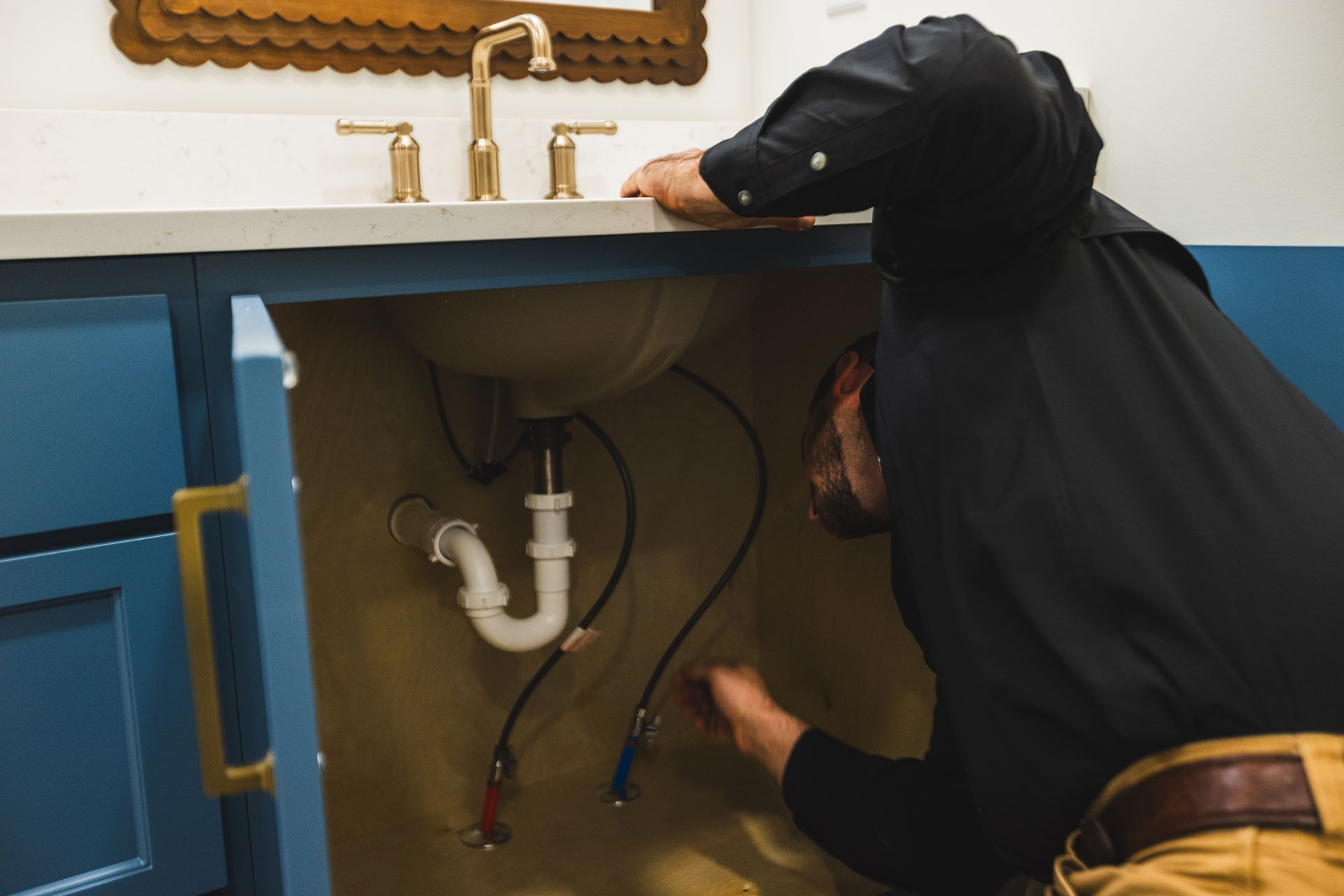A plumber working on a faucet installation for a sink.
