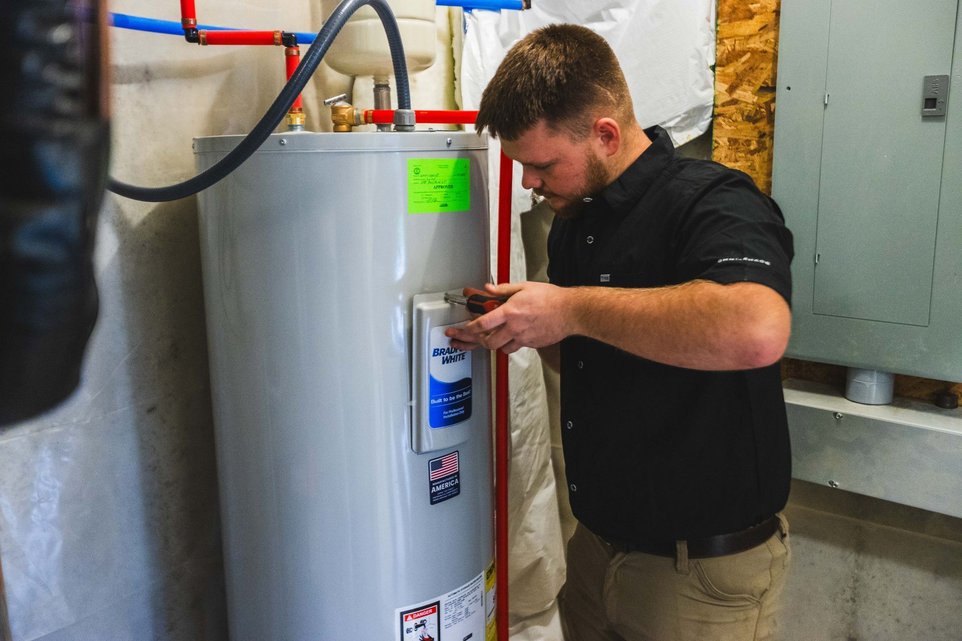 Plumber performing discounted plumbing on a residential water heater unit.