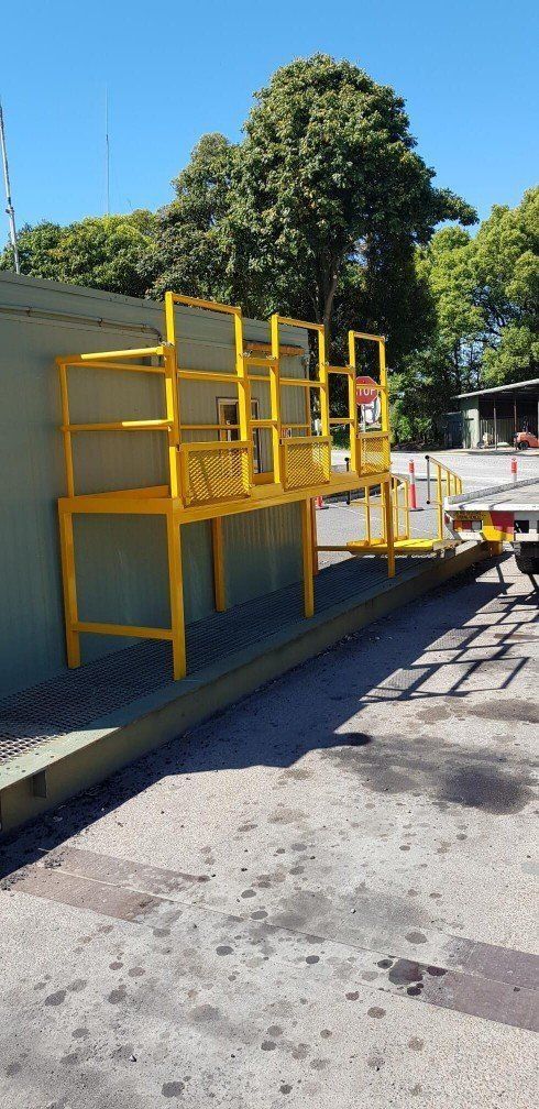 There is Yellow Steel Frames against a Work Shed — AWE Engineering in South Lismore, NSW