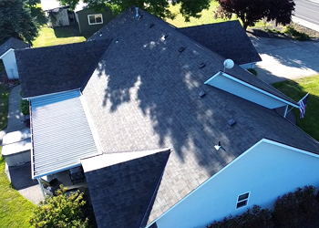 An aerial view of a house with a roof that is covered in shingles.