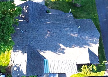 An aerial view of a house with a roof that is covered in shingles.