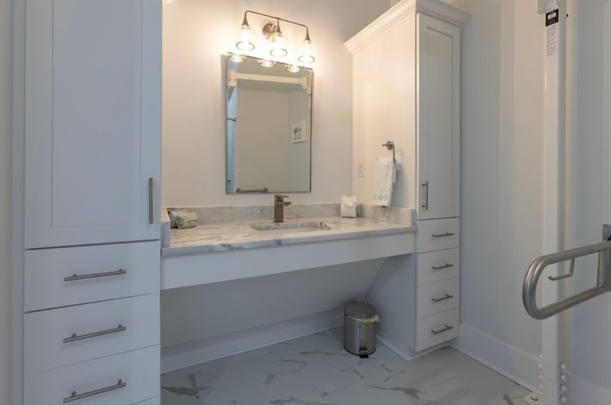 Wheelchair Accessible ensuite with roll under cabinetry, and xl- roll in shower with bench & hand held shower wand & bidet on toilet Roll under cabinetry in handicap accessible ensuite at Rest Ashore in Gulf Shores, Alabama