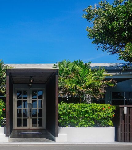 A house with a covered entrance and a tree in front of it