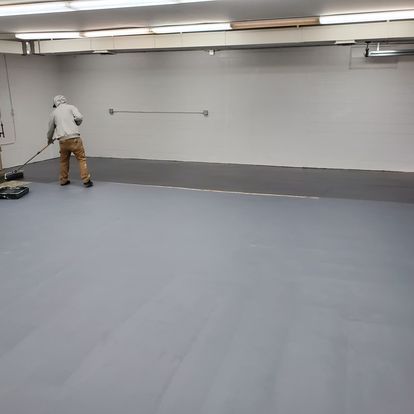 A man is cleaning the floor of a room with a vacuum cleaner.