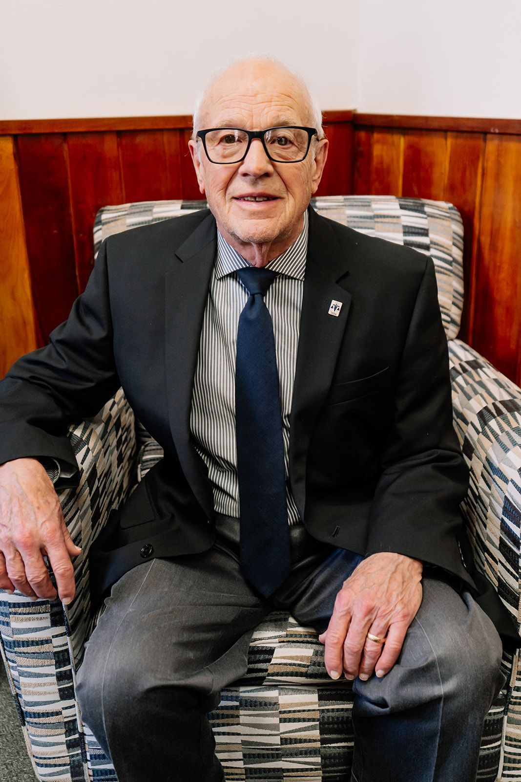 A man in a suit and tie is sitting in a chair.
