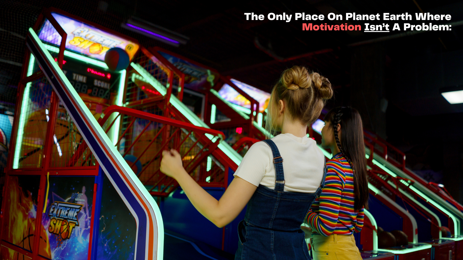 Two women are playing an arcade game in an amusement park.